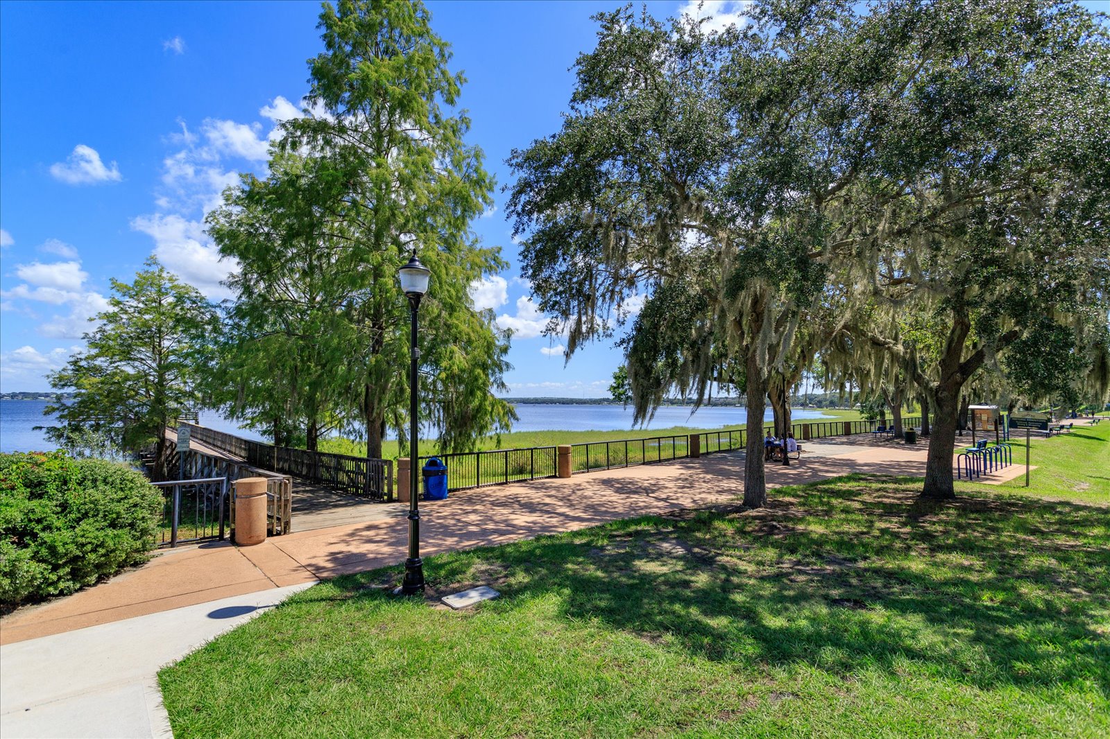 Lakefront walking trail under cypress and oak trees along Lake Minneola